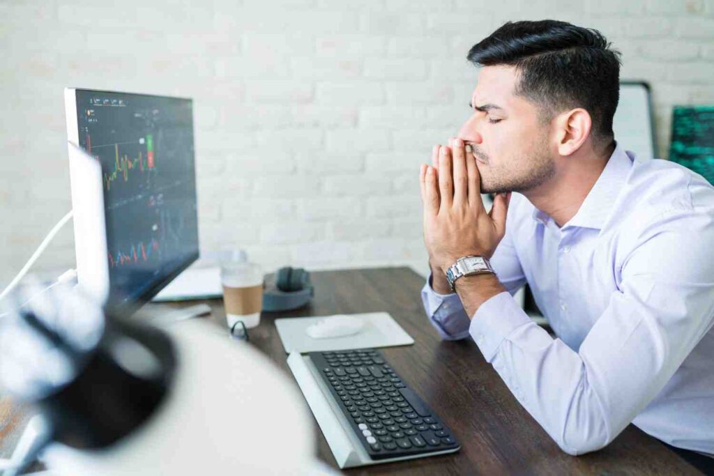 Trader sitting in front of trading charts while practicing patience and emotional discipline during market analysis.