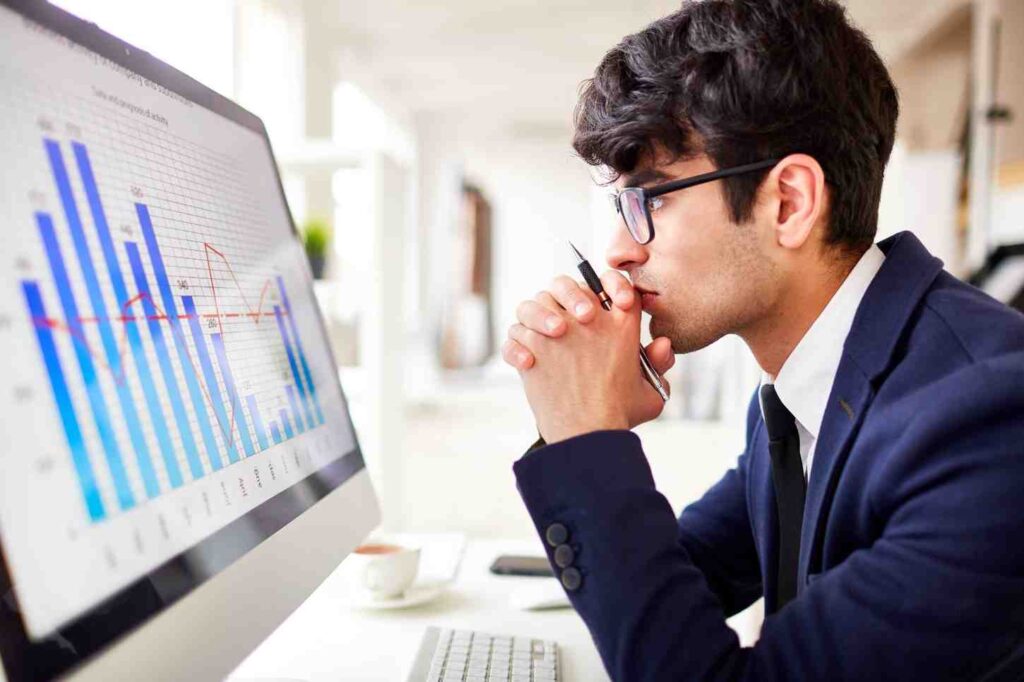 Trader analyzing charts and market data on a computer screen, representing disciplined decision-making, process-focused trading, and long-term consistency over short-term results.
