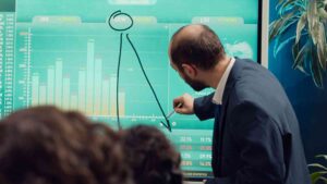 Trader analyzing charts and market data with focus and patience, representing how process-based trading improves discipline by encouraging consistent execution, risk management, and adherence to a trading plan.