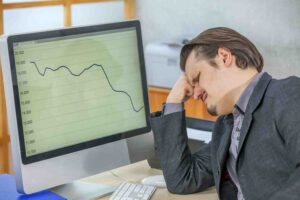 ### Alt Text
Trader reviewing market charts after an unexpected price move, illustrating the problems with prediction-based trading and the risks of relying on forecasts instead of adapting to changing market conditions.