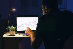 Trader analyzing charts and market data while forecasting future price movements, illustrating what predicting means in trading and the attempt to anticipate market direction before it occurs.